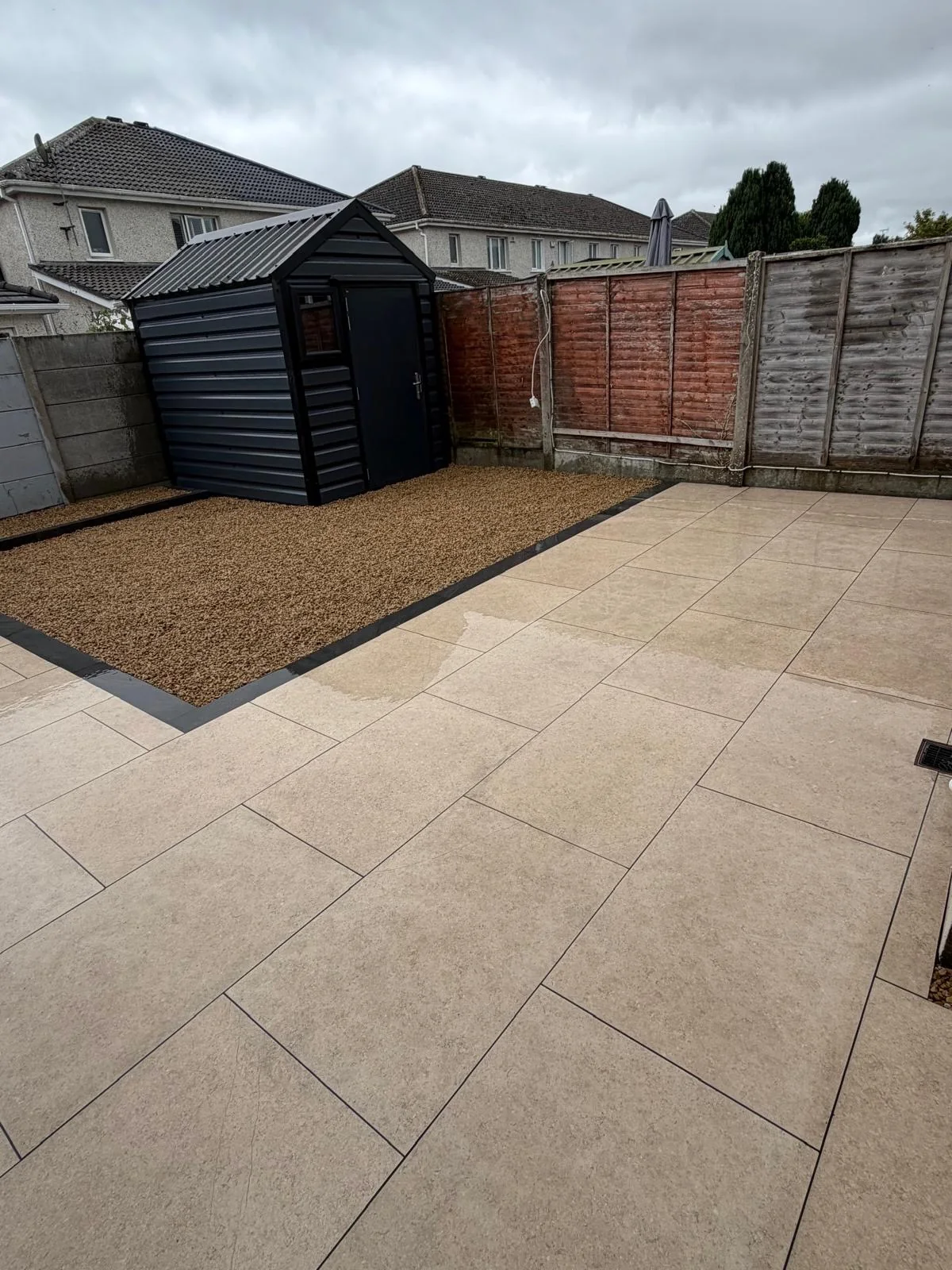 Cream porcelain patio with gravel area and garden shed